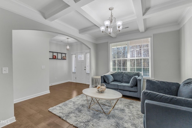 living room with an inviting chandelier, coffered ceiling, ornamental molding, dark hardwood / wood-style flooring, and beamed ceiling