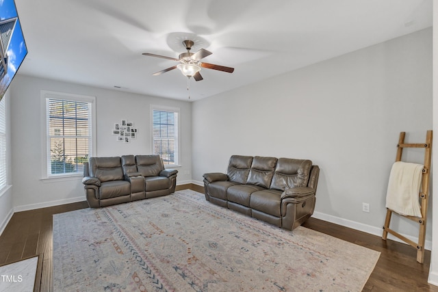 living room with dark hardwood / wood-style flooring and ceiling fan