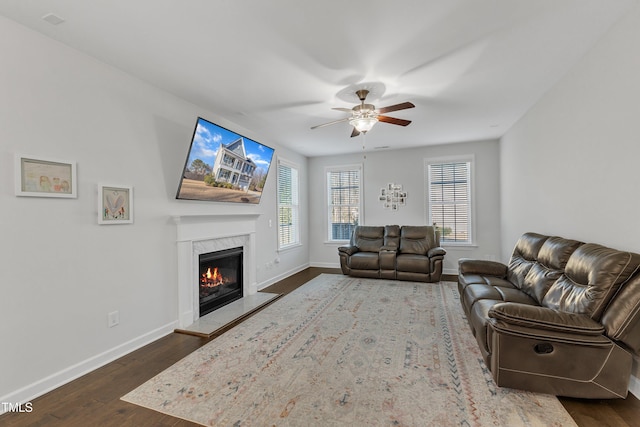 living room with ceiling fan, a fireplace, a healthy amount of sunlight, and dark hardwood / wood-style floors