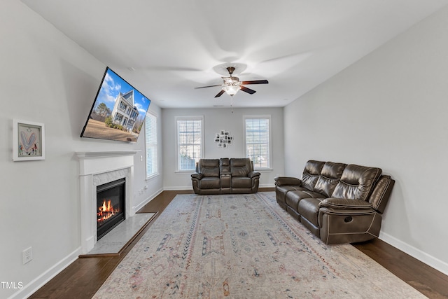 living room with ceiling fan, a fireplace, and dark hardwood / wood-style flooring