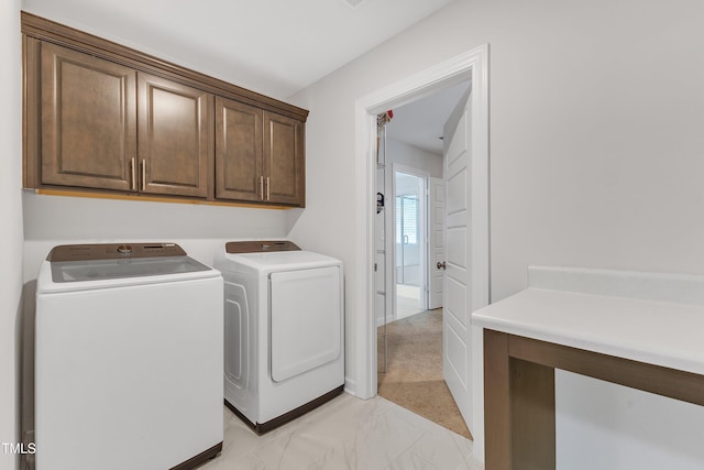 laundry area with washing machine and dryer and cabinets