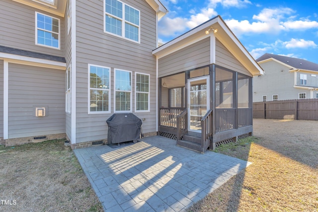 rear view of property with a sunroom and a patio area