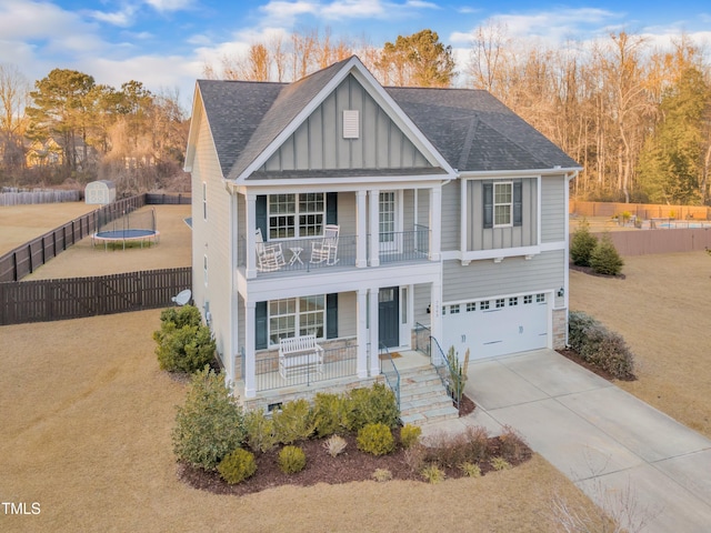 view of front of property with a garage, a front lawn, a balcony, and covered porch