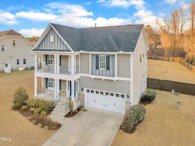 view of front facade featuring a garage, a front lawn, a balcony, and a porch