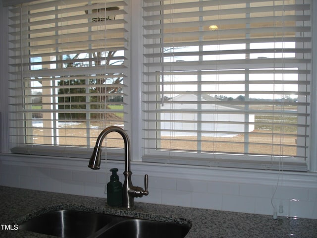 details with sink, backsplash, and stone counters