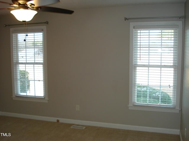 empty room featuring ceiling fan and carpet