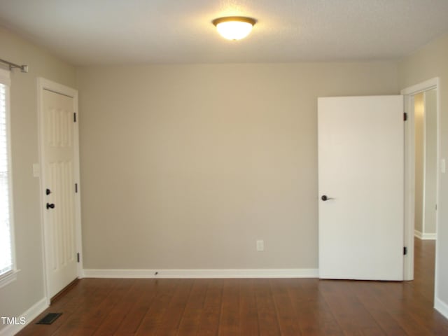 empty room featuring dark wood-type flooring