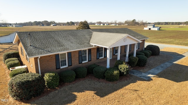 view of property exterior with a lawn and a rural view