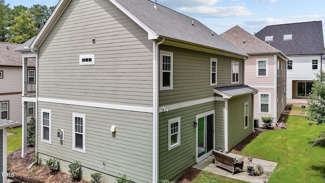 rear view of house featuring a yard and a patio area