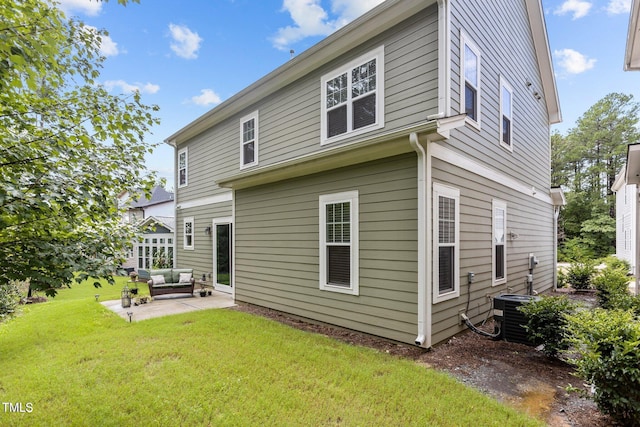 rear view of property featuring central air condition unit, a patio area, and a lawn