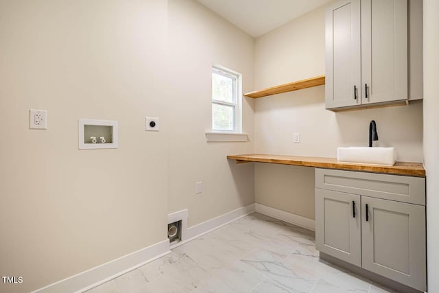 clothes washing area with cabinets, hookup for an electric dryer, hookup for a washing machine, and sink