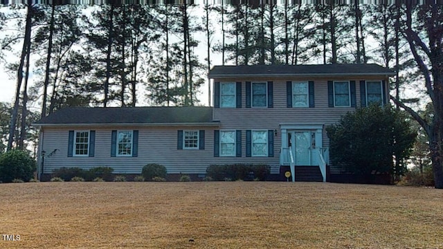 colonial-style house featuring a front lawn