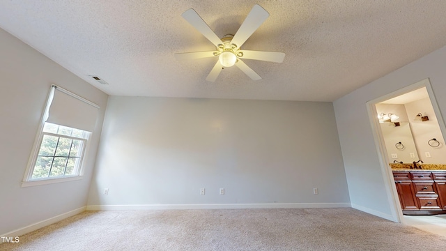 unfurnished room with ceiling fan, light carpet, and a textured ceiling