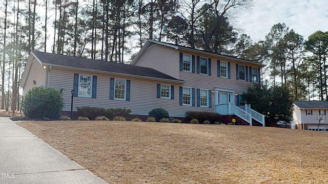 colonial home featuring a front lawn