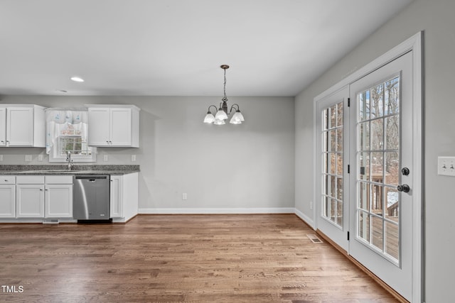 kitchen with white cabinets, decorative light fixtures, plenty of natural light, and dishwasher