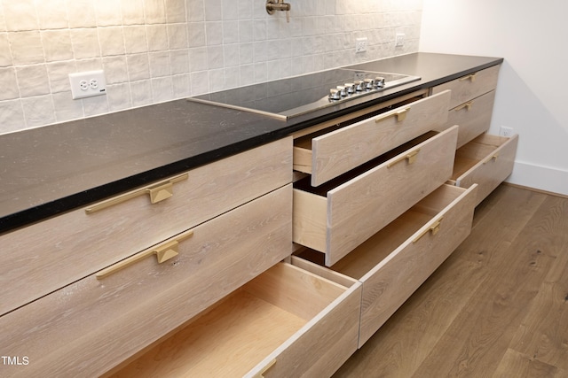 details with wood-type flooring, black electric stovetop, and decorative backsplash