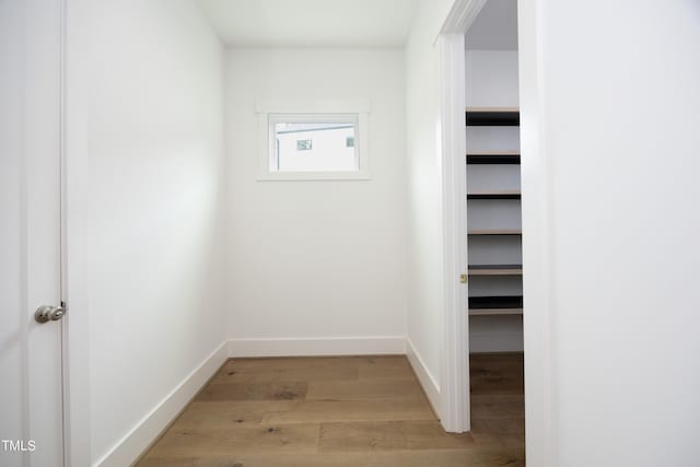 walk in closet with light hardwood / wood-style flooring