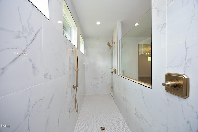 bathroom featuring tile patterned flooring, tile walls, and a tile shower