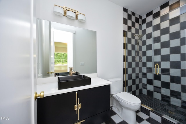 bathroom with vanity, a shower with door, and toilet