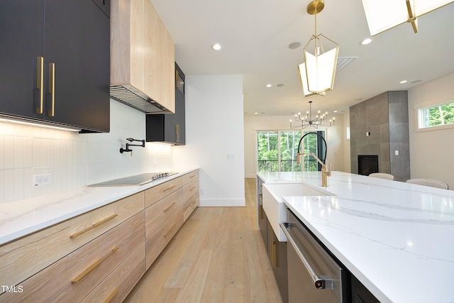 kitchen featuring pendant lighting, black electric stovetop, light stone counters, and light brown cabinets