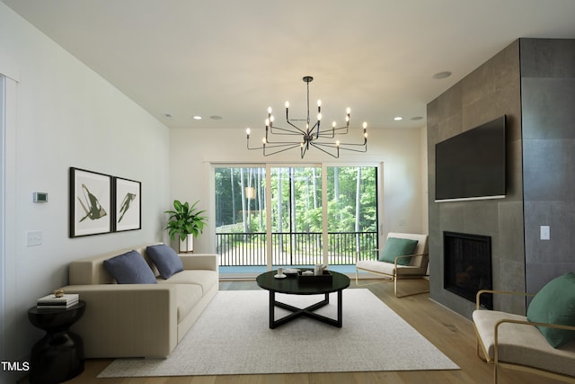 living room featuring a chandelier, a fireplace, and light hardwood / wood-style floors