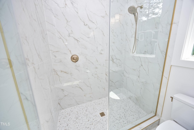 bathroom featuring tiled shower and toilet