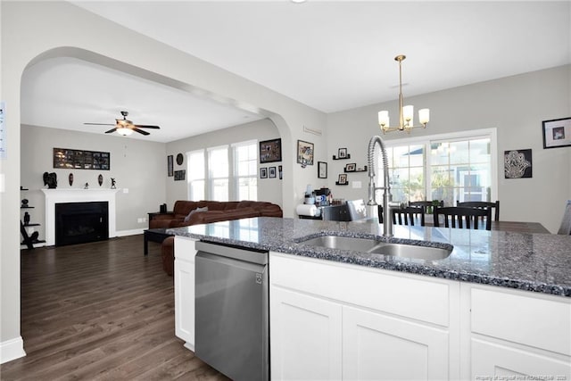 kitchen featuring pendant lighting, sink, dark stone countertops, white cabinets, and stainless steel dishwasher