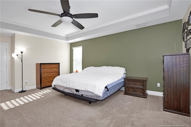 bedroom featuring crown molding, light carpet, ceiling fan, and a tray ceiling