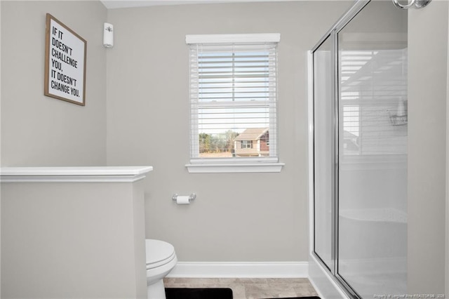 bathroom featuring tile patterned floors, toilet, and a shower with door