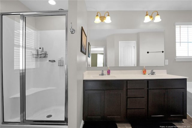 bathroom featuring a shower with door and vanity