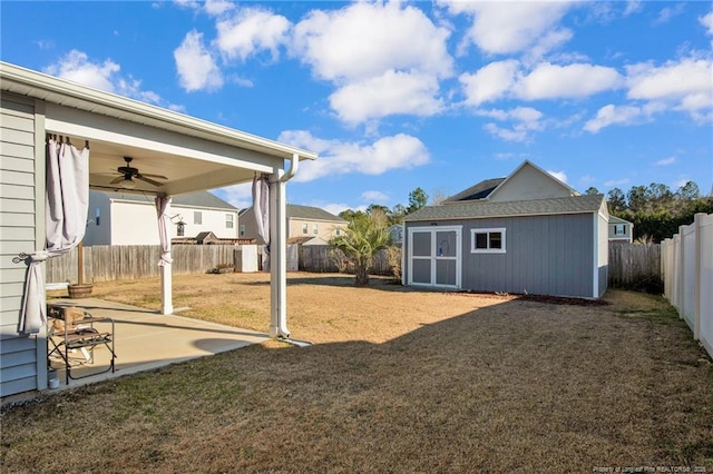 view of yard featuring a patio, ceiling fan, and a shed