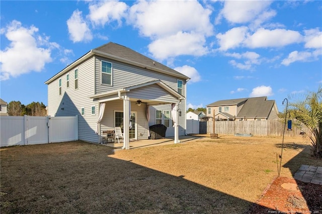 back of property with a lawn and a patio area