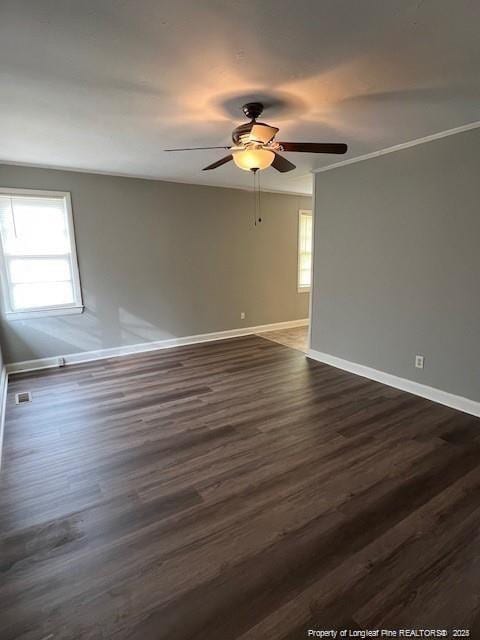 unfurnished room with dark hardwood / wood-style flooring, ceiling fan, ornamental molding, and a healthy amount of sunlight