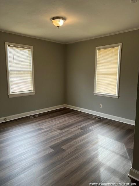 empty room featuring crown molding and dark wood-type flooring