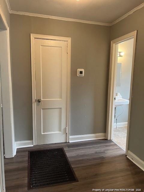 hallway with ornamental molding and dark hardwood / wood-style floors