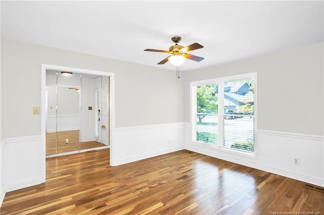 unfurnished room featuring hardwood / wood-style flooring, a wealth of natural light, and ceiling fan