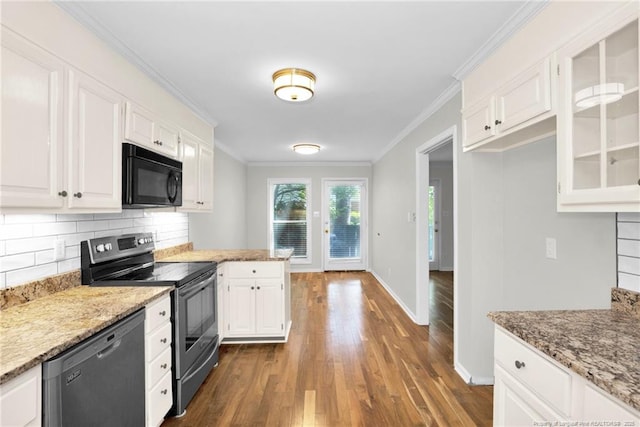 kitchen featuring white cabinetry, light stone countertops, tasteful backsplash, and black appliances