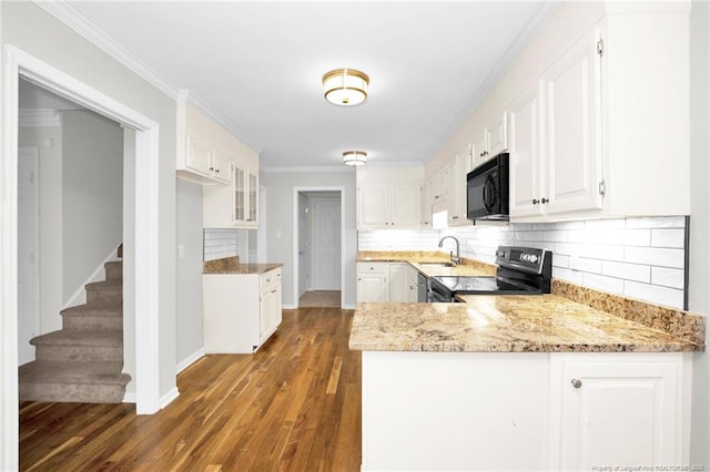 kitchen featuring sink, white cabinetry, black appliances, light stone countertops, and kitchen peninsula