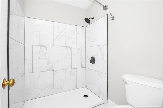 bathroom with tiled shower and toilet