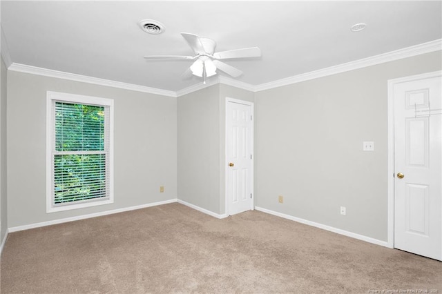 empty room featuring ceiling fan, light colored carpet, and ornamental molding