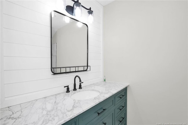 bathroom featuring vanity and wooden walls