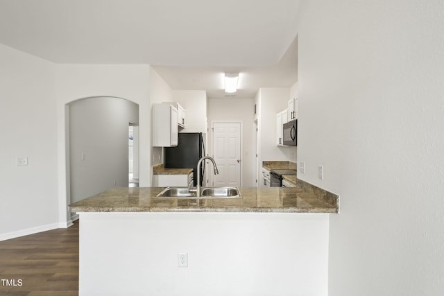 kitchen with white cabinetry, sink, black appliances, and kitchen peninsula