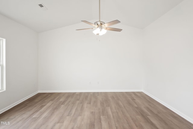 spare room featuring ceiling fan, vaulted ceiling, and light wood-type flooring