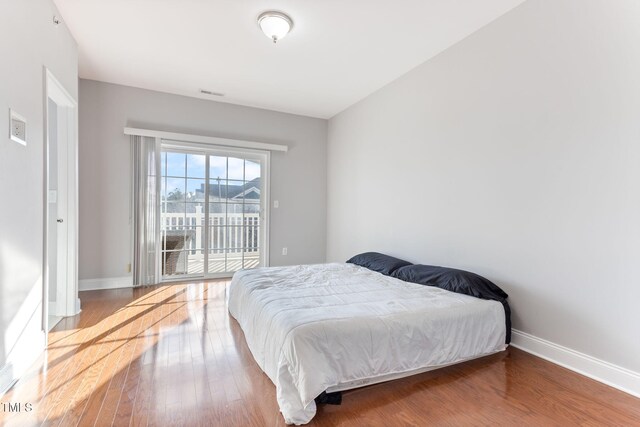 bedroom featuring hardwood / wood-style flooring and access to outside