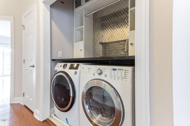 washroom with washer and clothes dryer and wood-type flooring