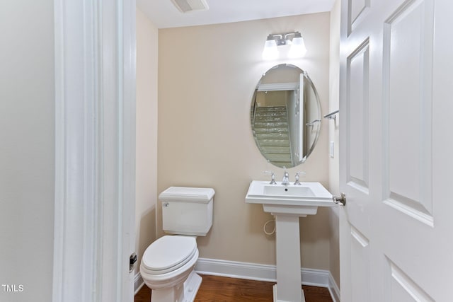 bathroom with hardwood / wood-style flooring and toilet