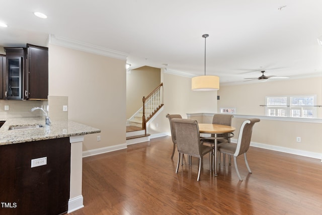 dining area featuring crown molding, ceiling fan, dark hardwood / wood-style flooring, and sink