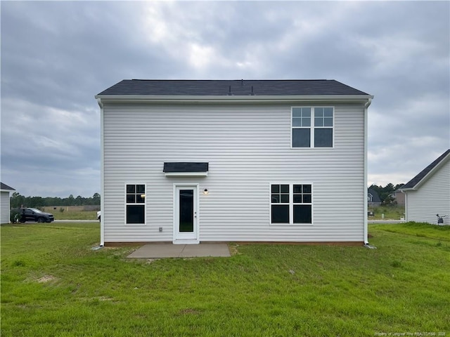 rear view of house with a patio and a lawn