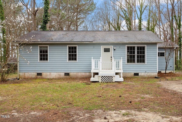 rear view of house featuring crawl space, a yard, and a shingled roof