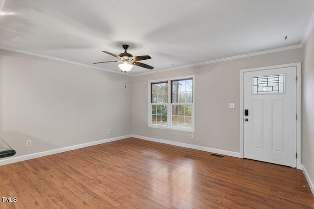 foyer with visible vents, baseboards, wood finished floors, and ornamental molding